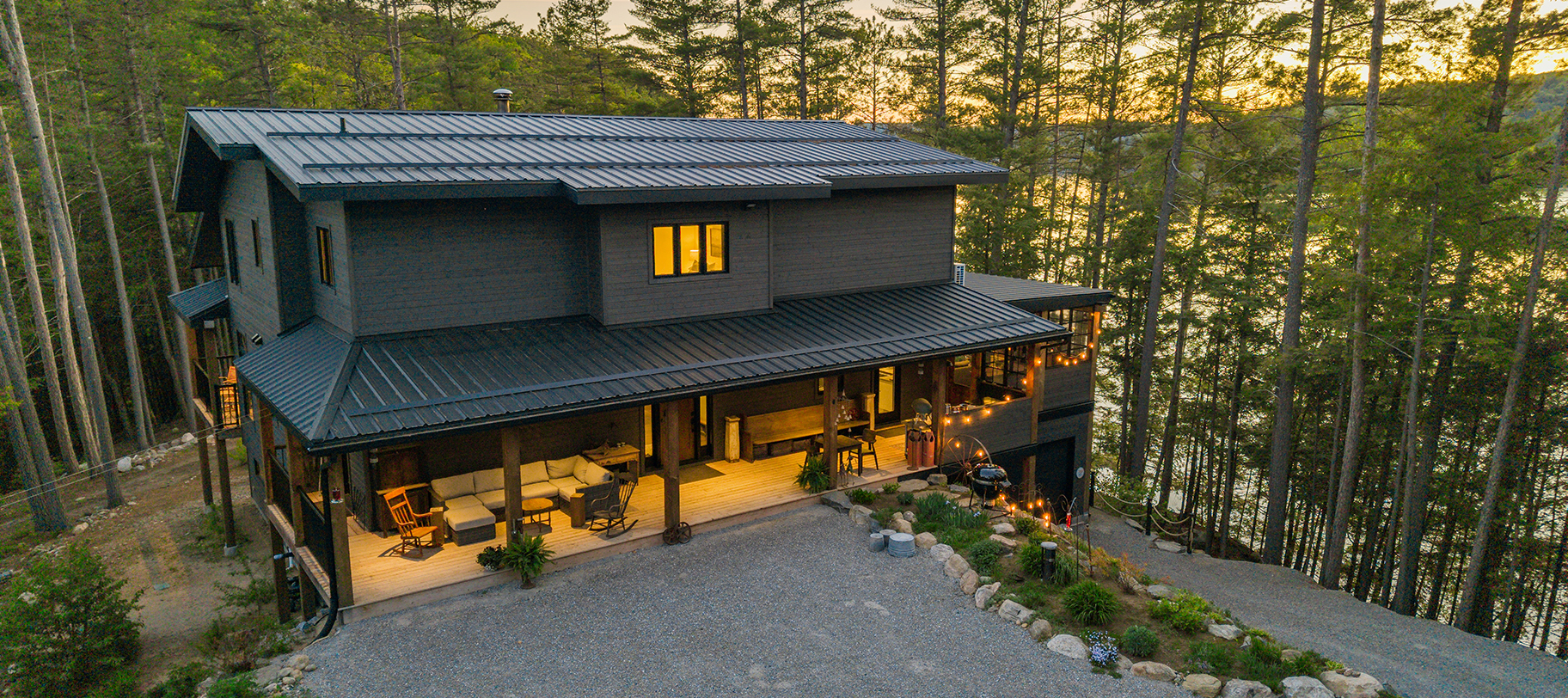 Aerial front view of the home with covered porch and winding drive